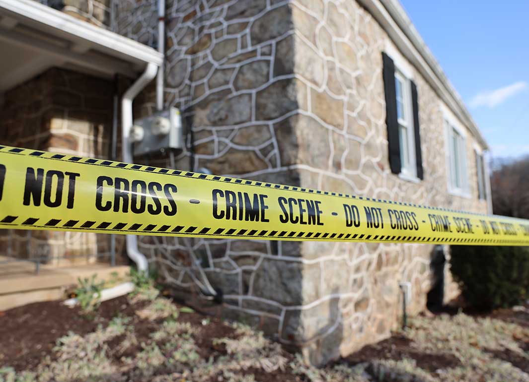 crime tape outside a stone house
