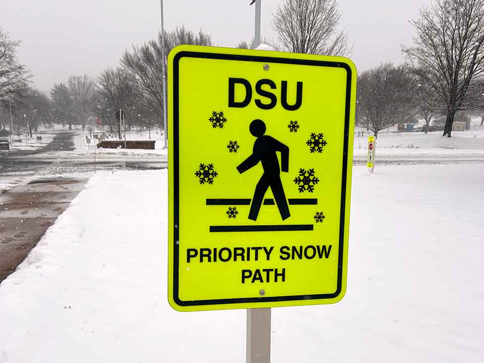 priority snow path sign on campus in winter