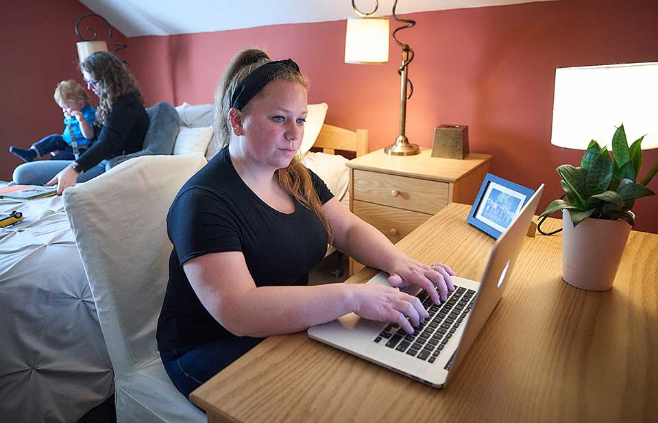 woman using laptop in bedroom