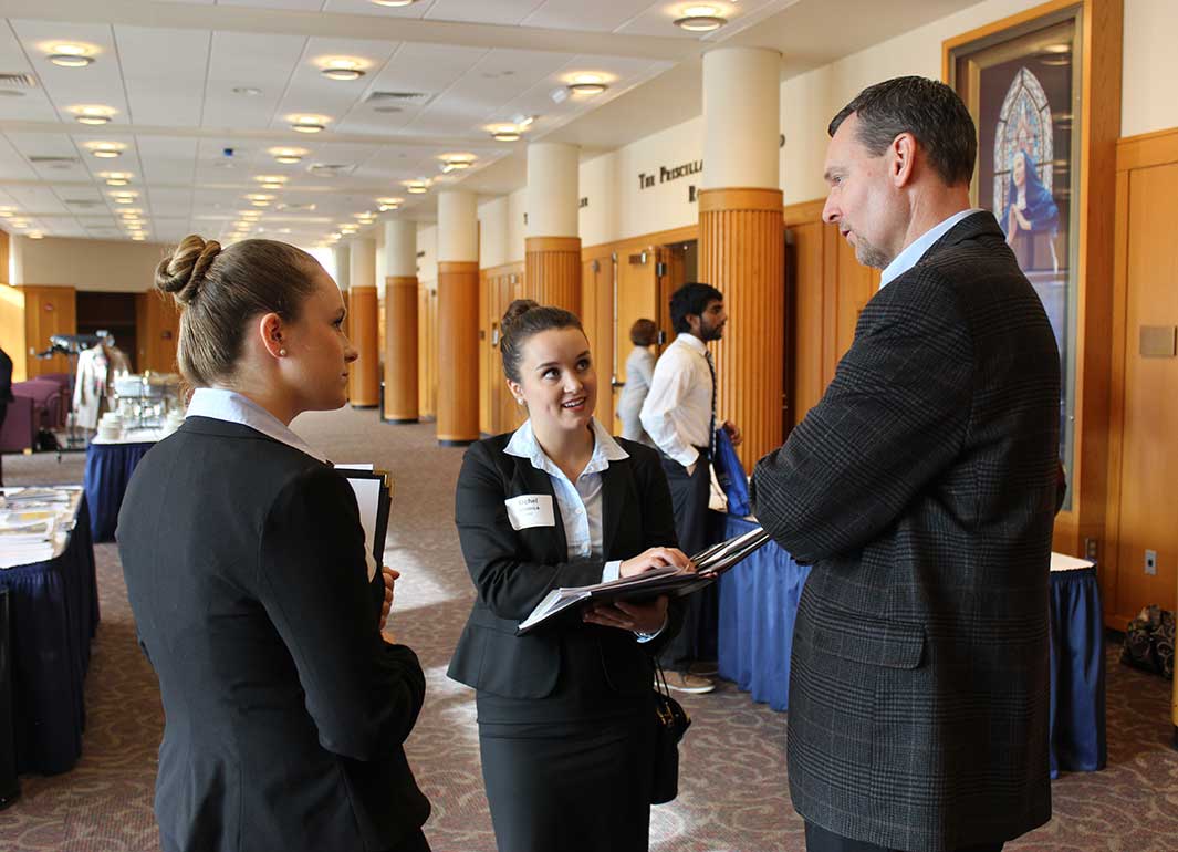 students networking with an alumni