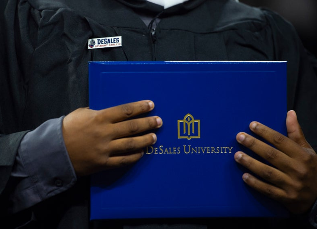 student holding a diploma