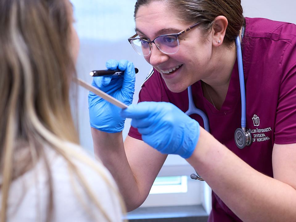 student nurse checking a patient's throat