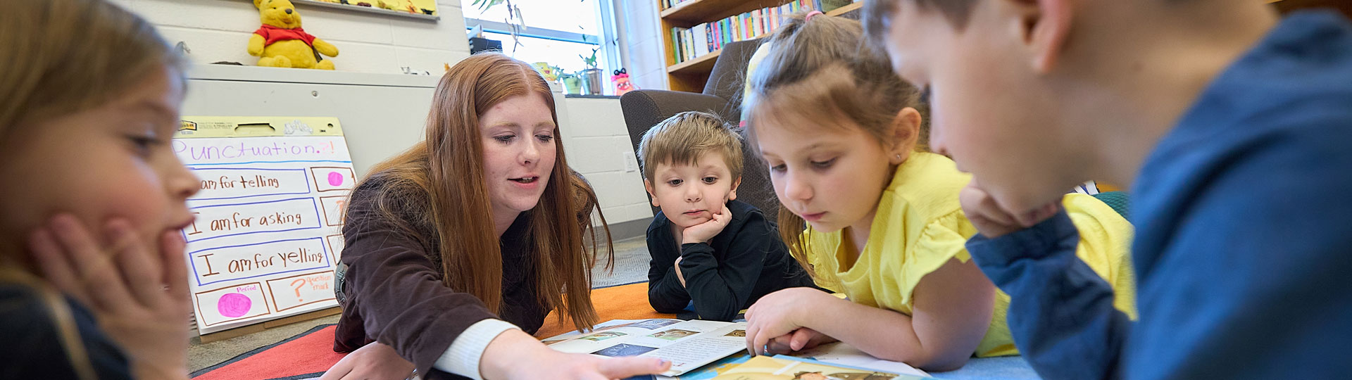 Girl teaching children how to read