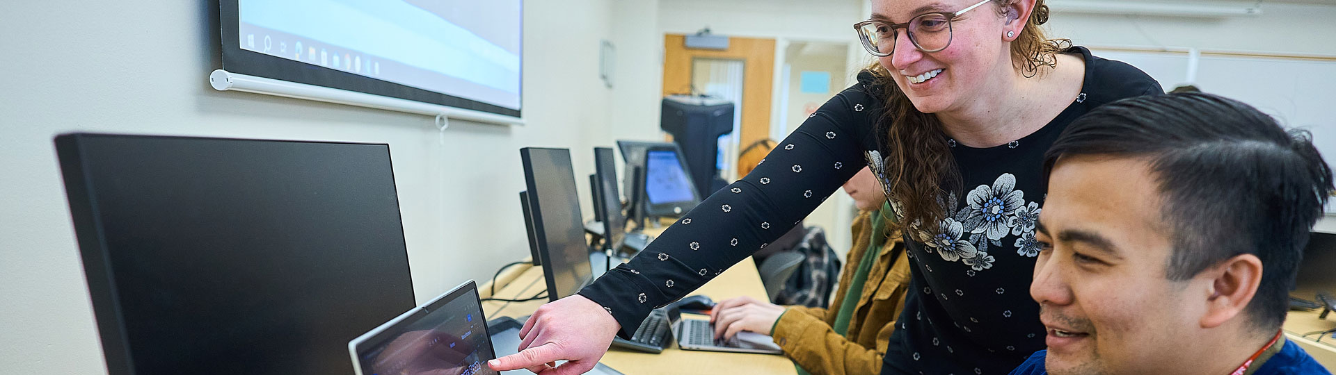 teacher helping a student on the computer