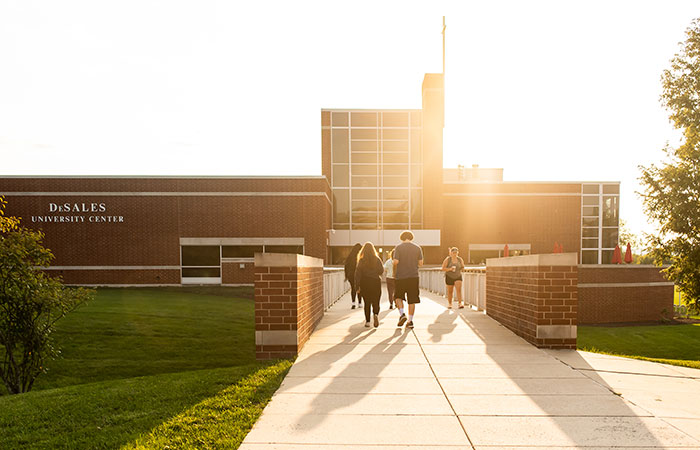 students walking on campus in front of building