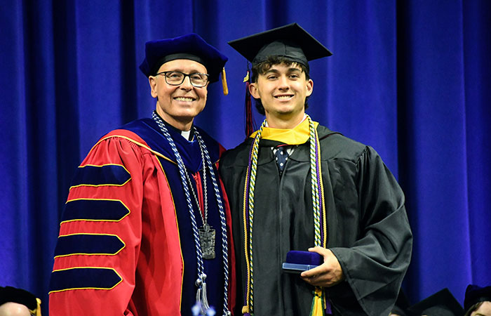 Student receiving medal from university president at commencement