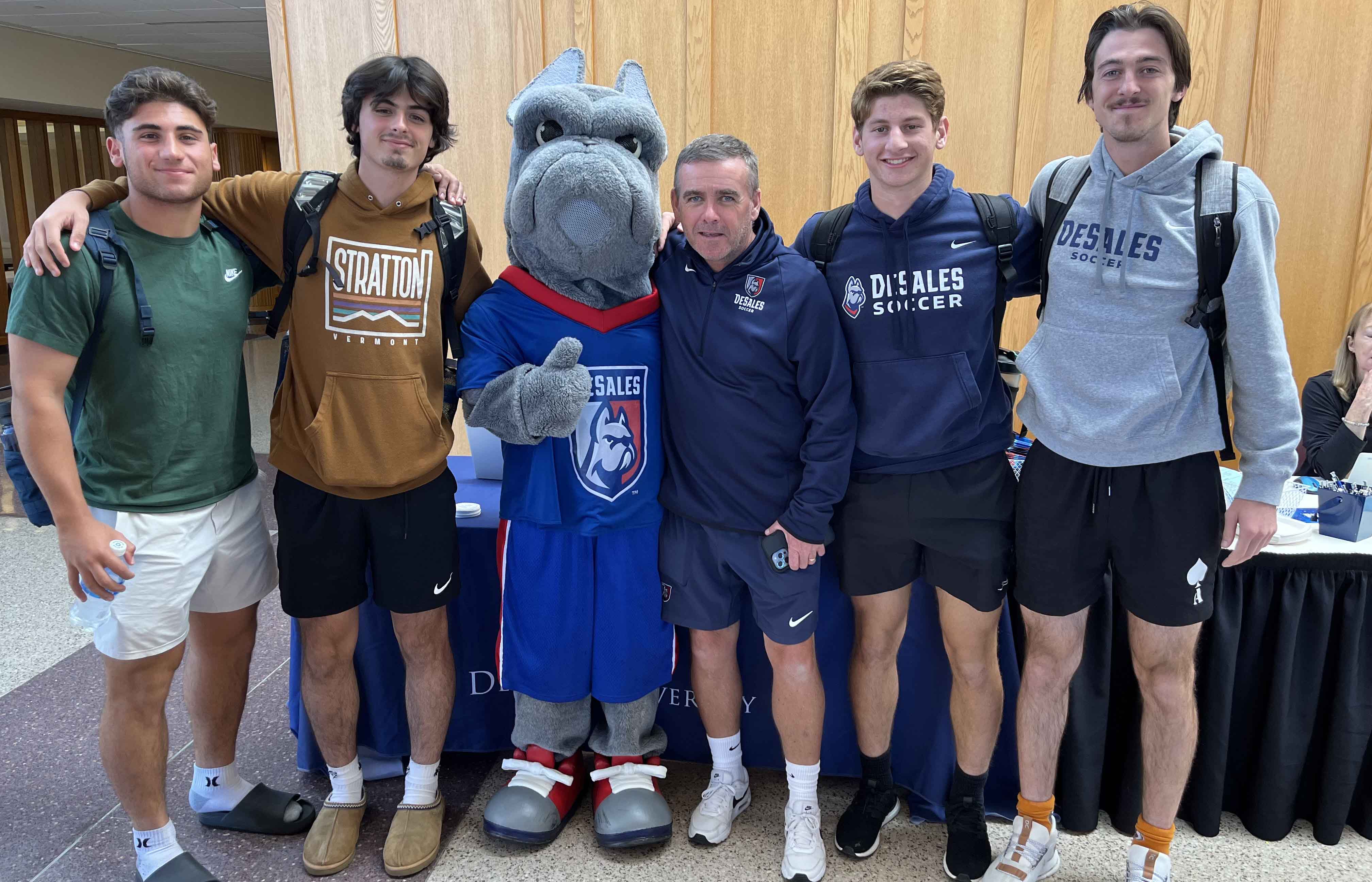 students with mascot and soccer coach