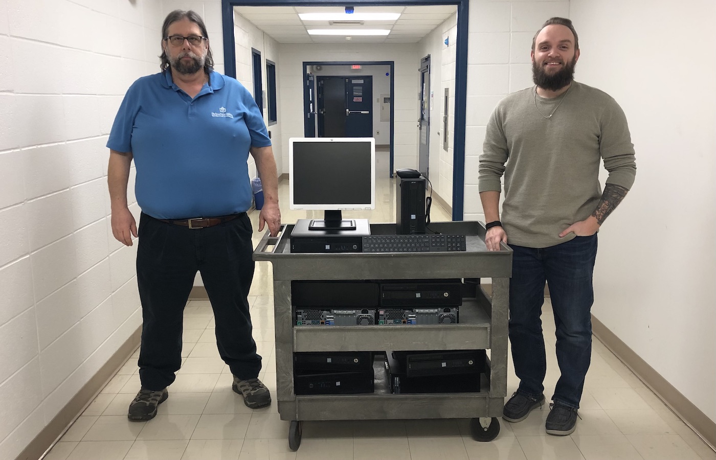 IT employees standing next to a cart of computers