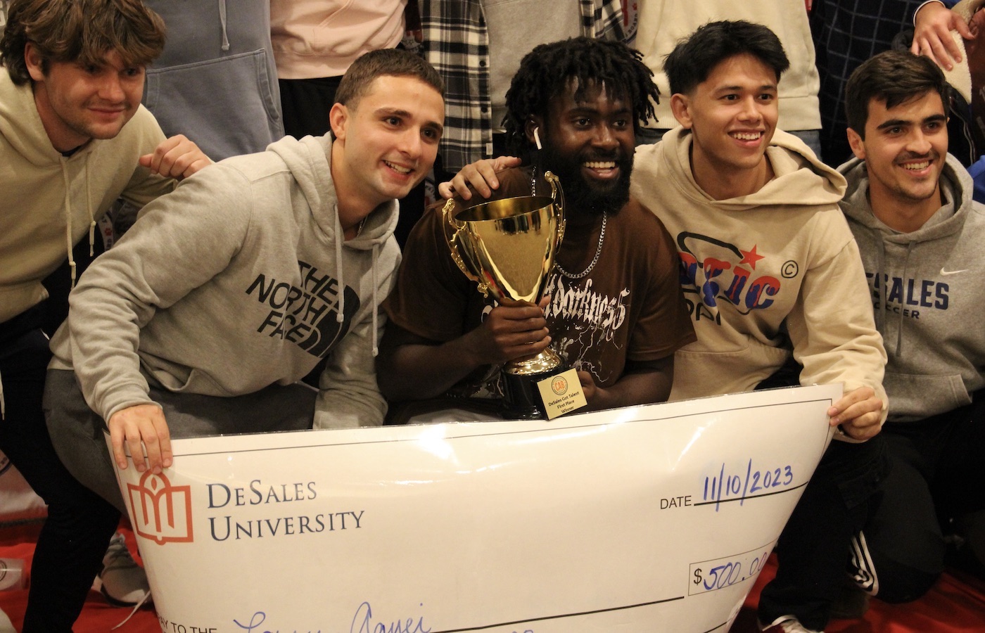 Students holding a trophy and a check