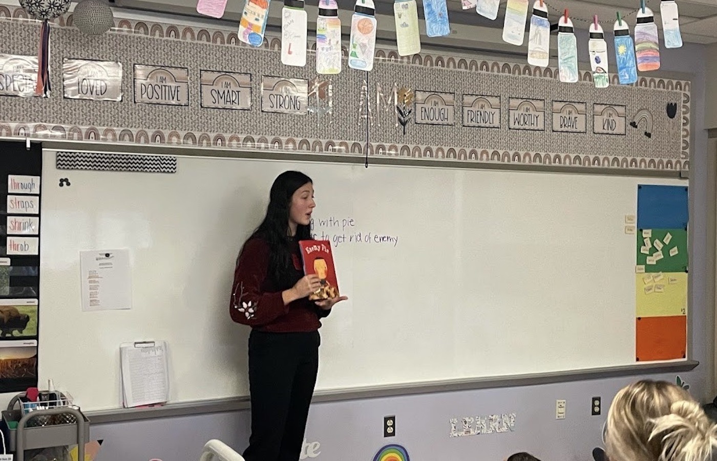 Girl talking about a book in a classroom