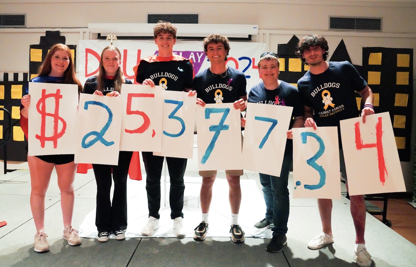 Students holding up the amount of money raised