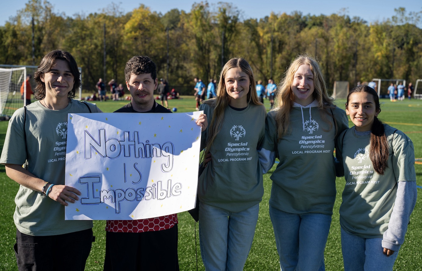 Students holding a sign that says "Nothing is Impossible"